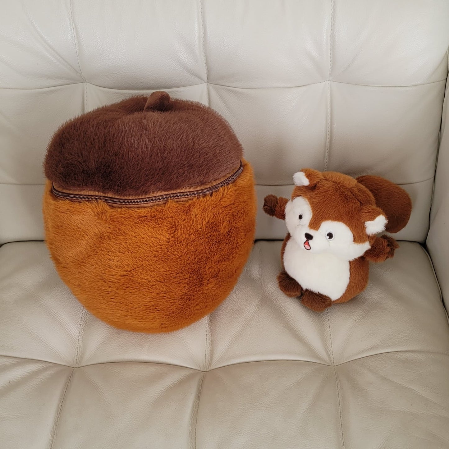 Two plush toys, one brown and one white and brown, on a light-colored couch.