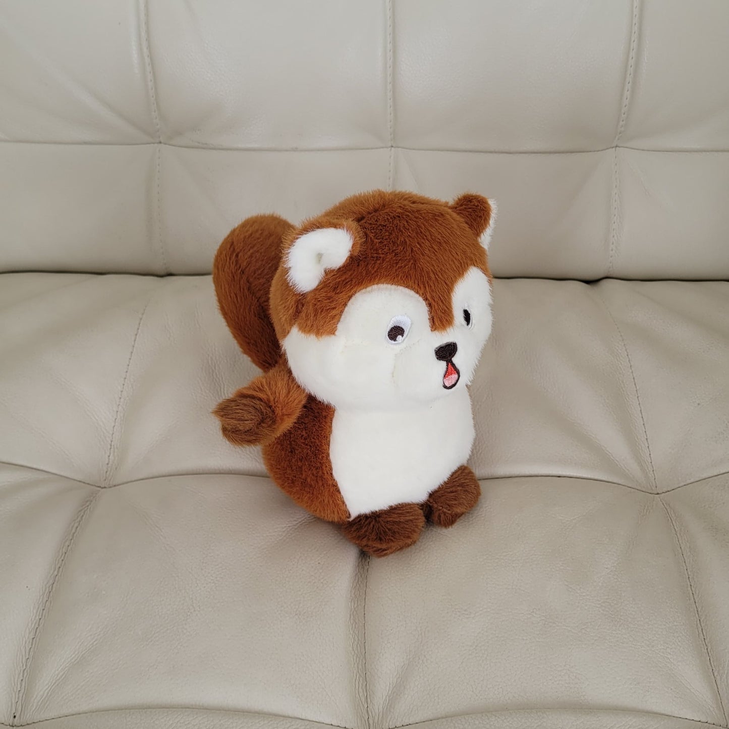 a squirrel plush toy on a couch
